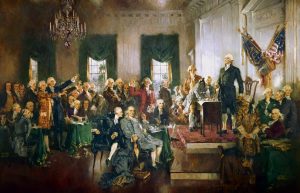 A public domain picture of a painting, "Scene at the Signing of the Constitution of the United States" by Howard Chandler Christy that shows 18th century lawmakers gathered in a formal room
