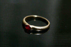 photo of a gold ring with a small ruby stone