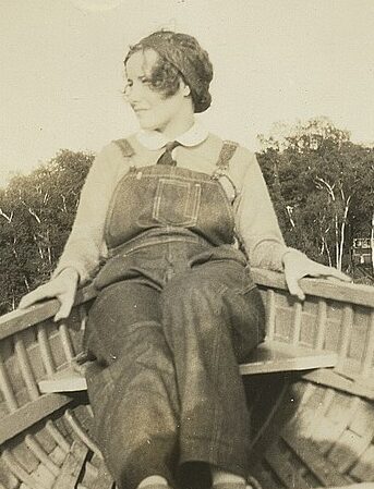 picture of girl in overalls sitting in a boat
