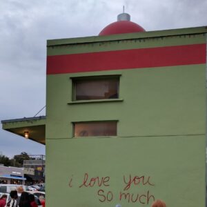 photo of a green building with "i love you so much" written on the side