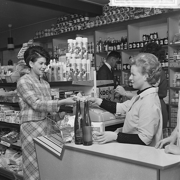 Public Domain image of a customer and checkout woman in a grocery from the Dutch National Archives, donated in the context of a partnership program.